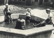 603476 Afbeelding van pootjebadende kinderen in de bak van de fontein in de pandhof (Domplein) te Utrecht.